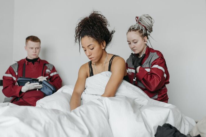 Medical professionals attending to a distressed patient in bed, showing consequences of patient mistakes.