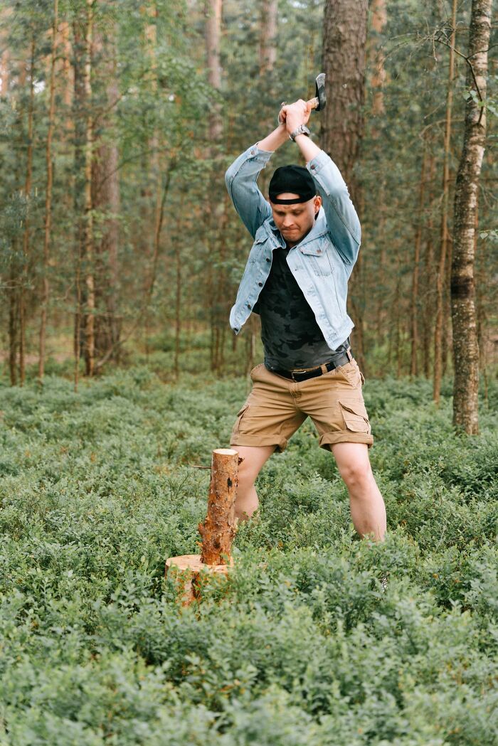 A man chops wood in a forest, demonstrating a poor choice that could lead to medical education cases.