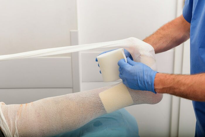 Medical professional applying a bandage to a patient's leg, highlighting common patient mistakes.