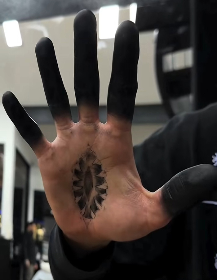 A hand showing a dramatic fingertip tattoo style with solid black ink completely covering all five fingertips. A hand showing a dramatic fingertip tattoo style with solid black ink completely covering all five fingertips.