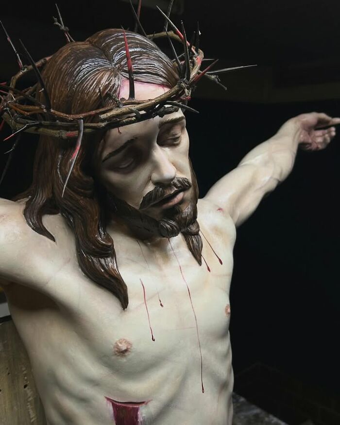 A detailed wood sculpture depicting Jesus Christ on the cross, created by a Polish artist.
