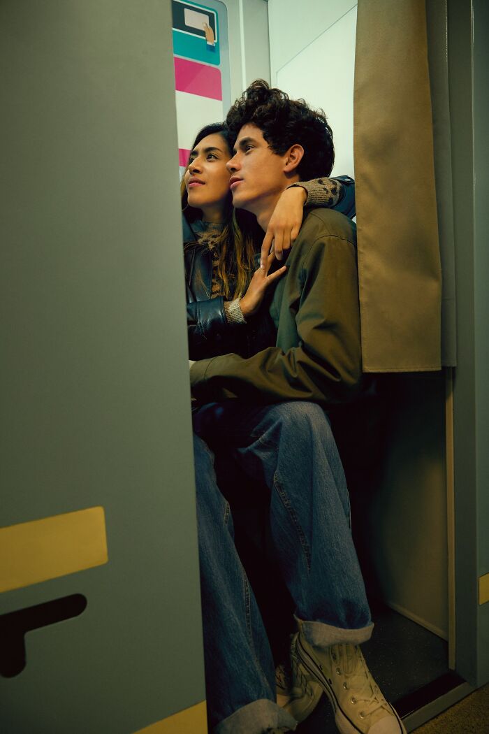 A young couple sits closely in a photo booth, illustrating reasons men lose interest in a woman instantly
