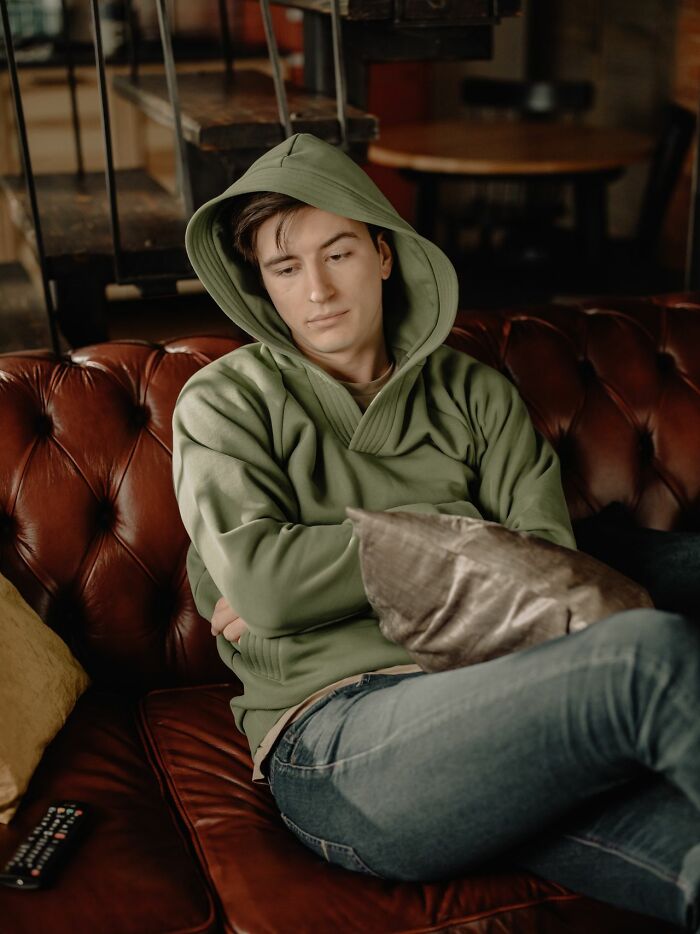 A thoughtful man on a leather couch, illustrating when men lose interest in a woman