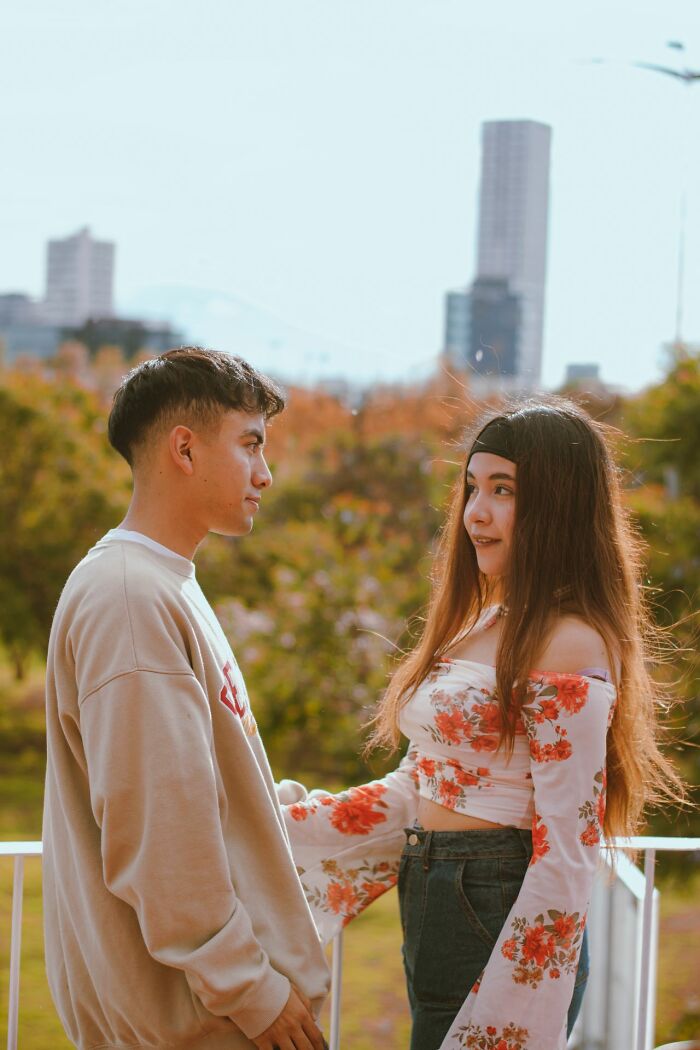 Young couple interacting outdoors, highlighting behaviors that make men lose interest in a woman