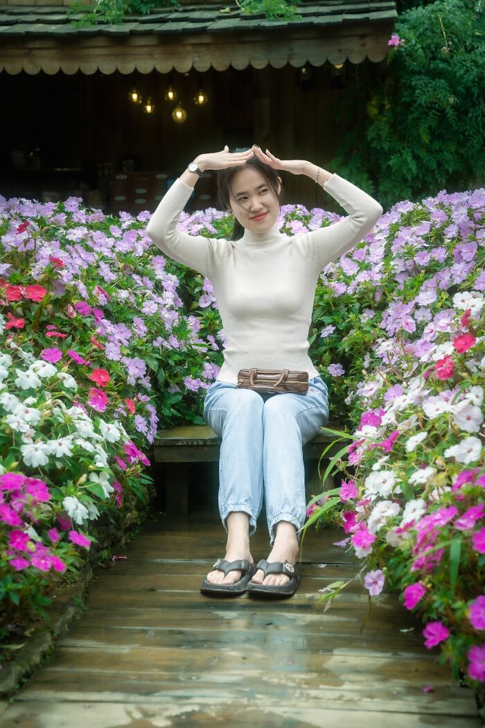 A happy young woman sitting in a colorful garden, highlighting how men lose interest in a woman.