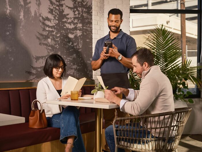 A couple looking at menus in a restaurant, illustrating a situation where men lose interest.