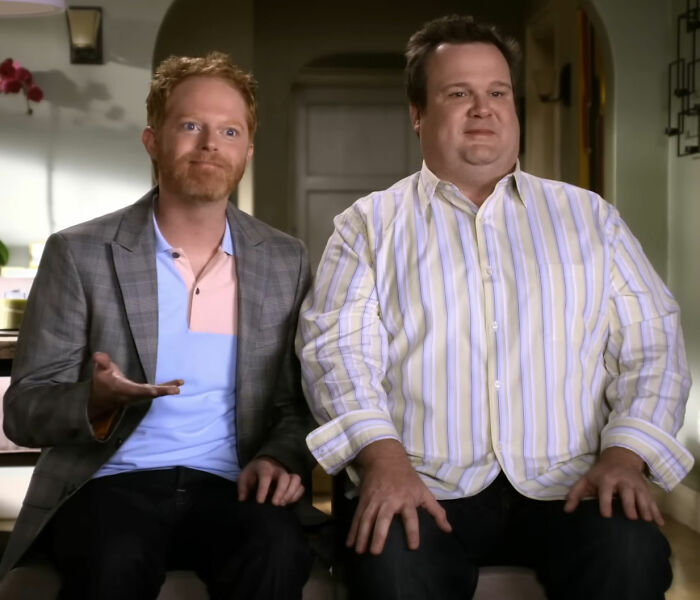 Modern Family reunion pic showing Mitch and Cam seated, baffling fans who don't recognize a major figure.