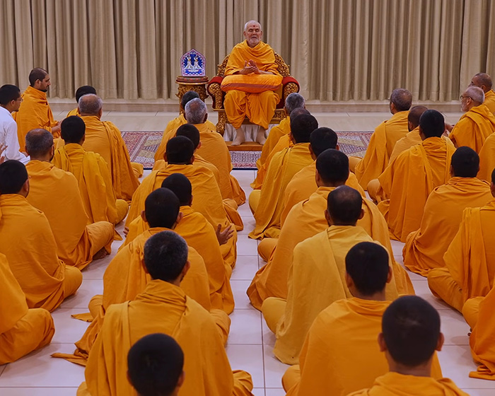 Hindu guru addressing a group of men, amidst outrage over Eiffel Tower closure.