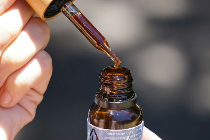 A dropper bottle with brown liquid, representing historical liquid medical practices.