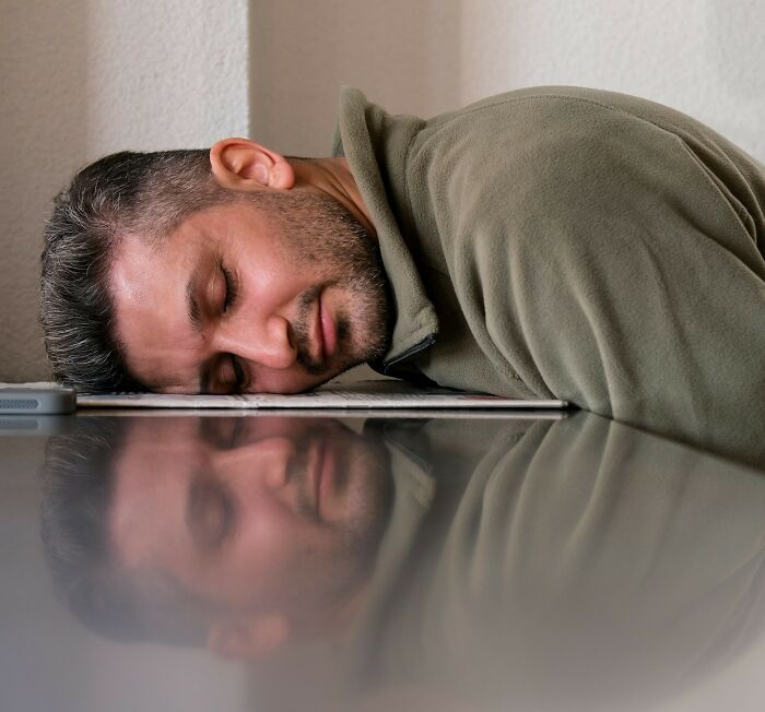 A tired man sleeping face down on a surface, reflecting exhaustion from clients lack of smartness shocking lawyers.