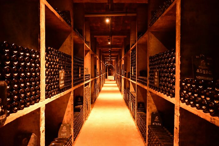 An underground wine cellar filled with stored wine bottles, representing contested assets in a split