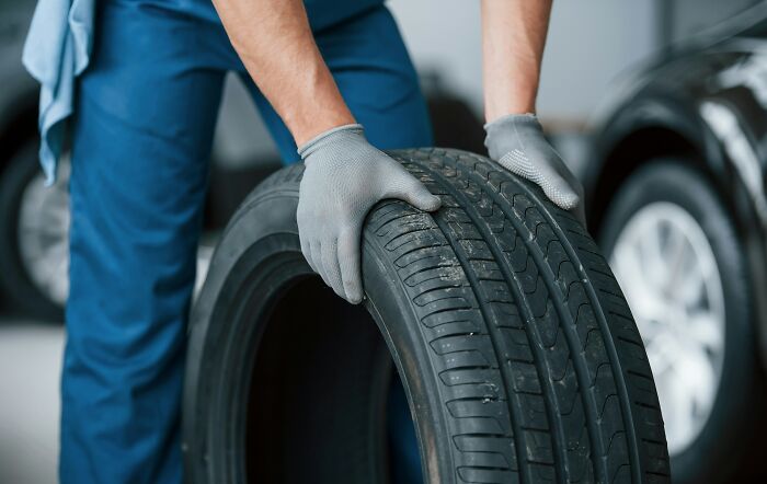 A mechanic holding a car tire, illustrating splitting assets and divorce disputes