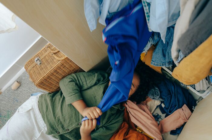 A messy closet floor filled with clothes as someone handles a difficult situation after a divorce split