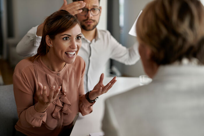 An angry woman arguing during a meeting, representing the intense split seen by divorce lawyers