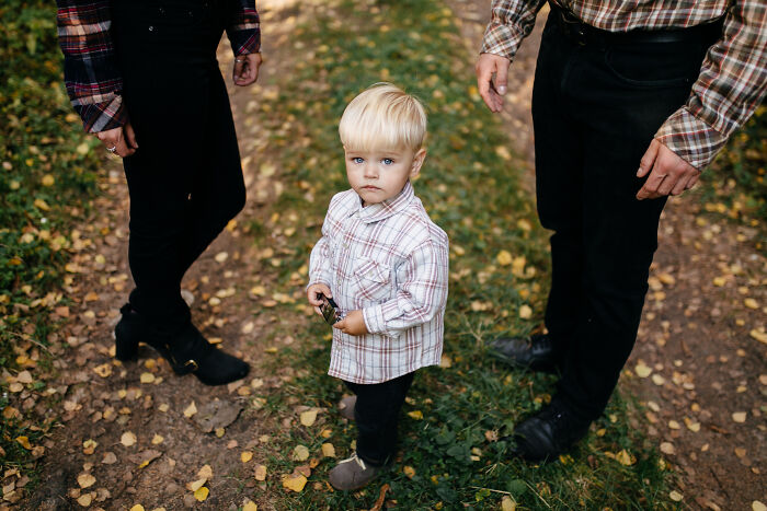 A young boy standing between his parents during a difficult split