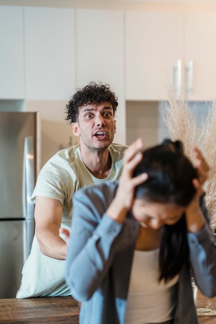 A man yelling at a woman who is covering her ears, depicting a moment of marriage conflict.