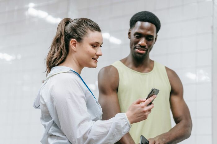 A woman and man looking at a phone, symbolizing a breakdown in marriage communication.