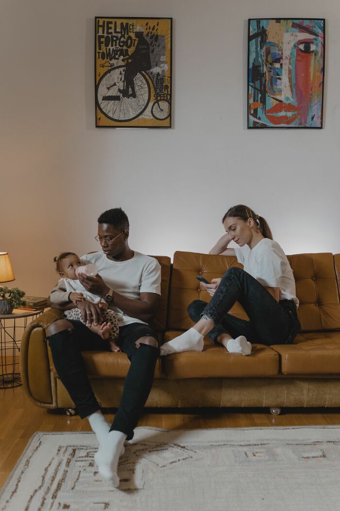 A couple on a couch, distant and focused on their phones, indicating a strained marriage.