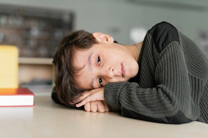 A young boy lies on a table looking sad, depicting heartbreaking moments a marriage was over.
