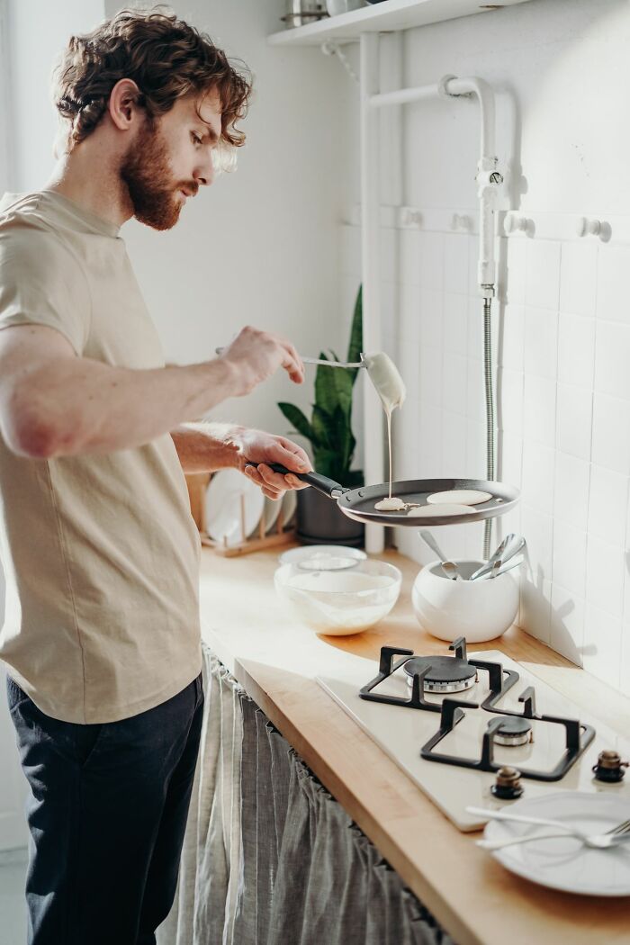 A man cooks pancakes, reflecting on heartbreaking moments a marriage ended.