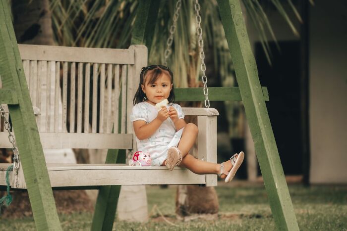 A young girl eating on a swing, symbolizing a child's experience during a marriage breakdown.