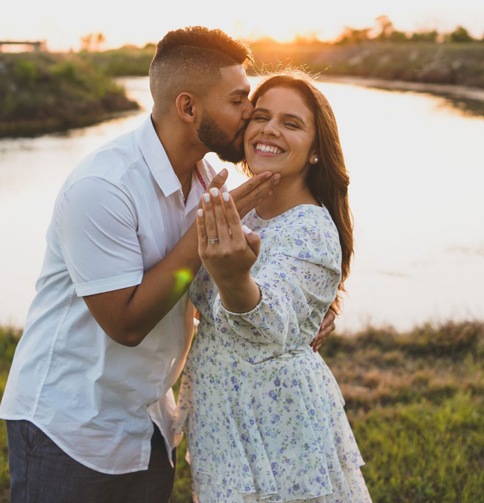 A happy couple at sunset celebrating their engagement with a wedding ring. A happy couple at sunset celebrating their engagement with a wedding ring.