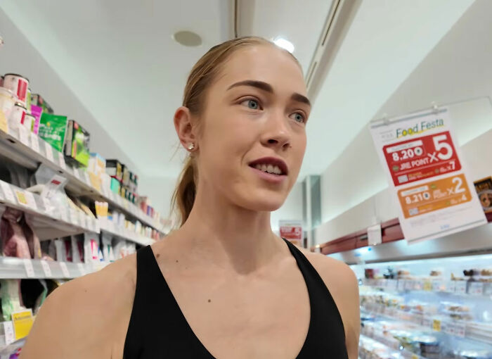HYROX athlete in a black top, looking determined in a supermarket aisle.