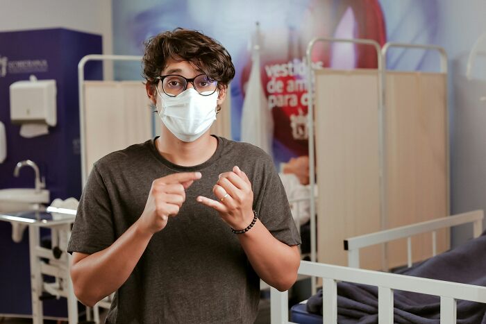 A medical staff wearing a face mask looks confused in a hospital setting