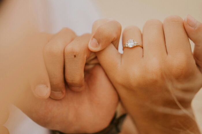 Two people holding pinky fingers, a symbol of friendship, but one realized their friends were actually haters.