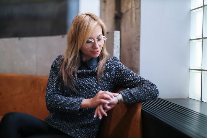 A woman looking at her watch, realizing that her friends were actually her haters.
