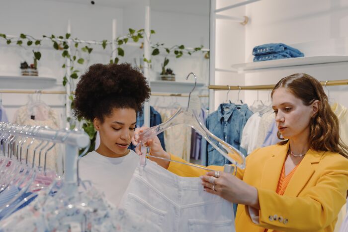 Two women shopping, one potentially realizing a friend's true nature as a hater.