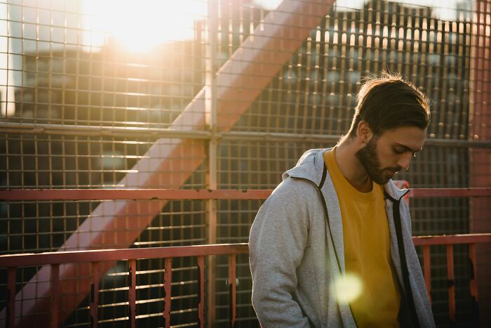 A man looking down, contemplating if his friends are really his haters.