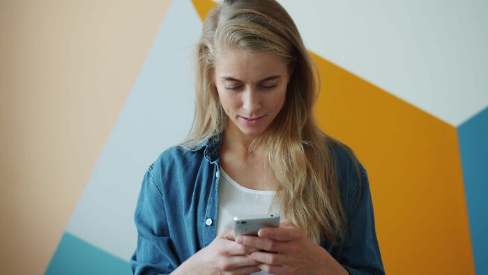 A woman looking at her phone, realizing her friends are actually haters.