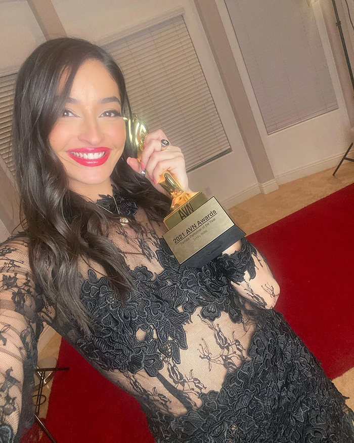 Emily Willis, paralyzed actress, smiles holding an award, revealing a sign of her life before her locked-in state.