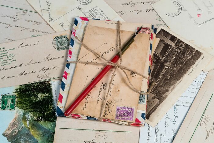 Stack of old letters and postcards, tied with twine, revealing secrets after people keeping them were gone.