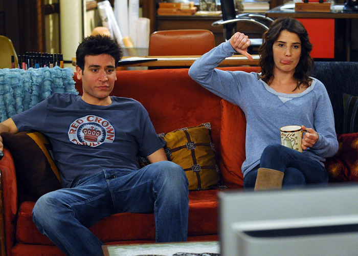 Two characters sitting on a couch reacting, highlighting a divisive hit show from 21 years ago Two characters sitting on a couch reacting, highlighting a divisive hit show from 21 years ago