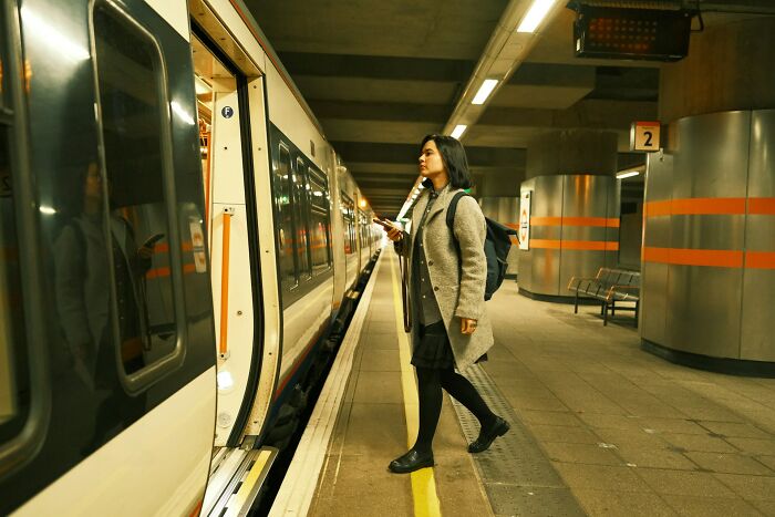 A woman waiting to board a train, an everyday action people might judge others for.