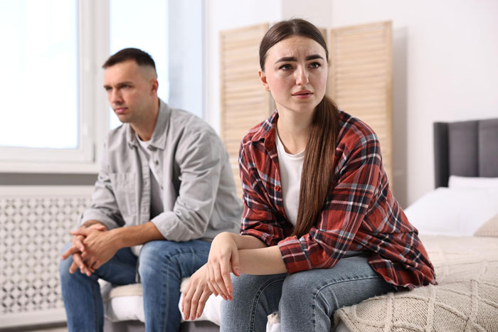 Couple sitting apart looking upset during martial arts relationship conflict Couple sitting apart looking upset during martial arts relationship conflict