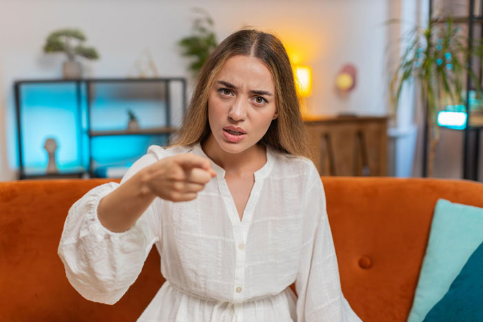 Angry woman pointing accusingly indoors, related to martial arts support conflict Angry woman pointing accusingly indoors, related to martial arts support conflict