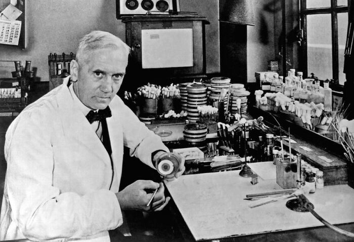 Black and white photo of scientist Alexander Fleming in his lab, a key moment in medical history.