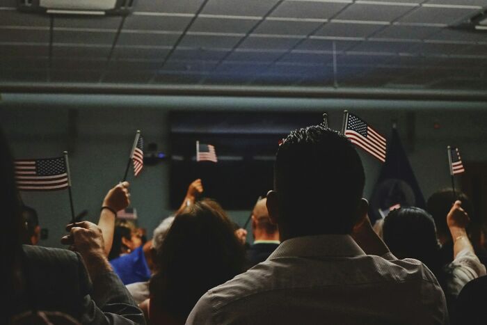 People holding small American flags at an indoor gathering. This emphasizes stupid things people said.