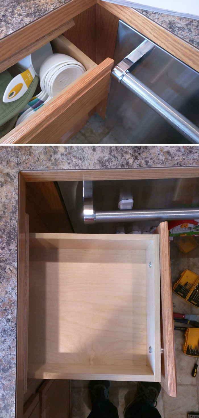 A questionable home improvement project in a kitchen, showing a wooden drawer that cannot fully open due to hitting the adjacent cabinet hardware.