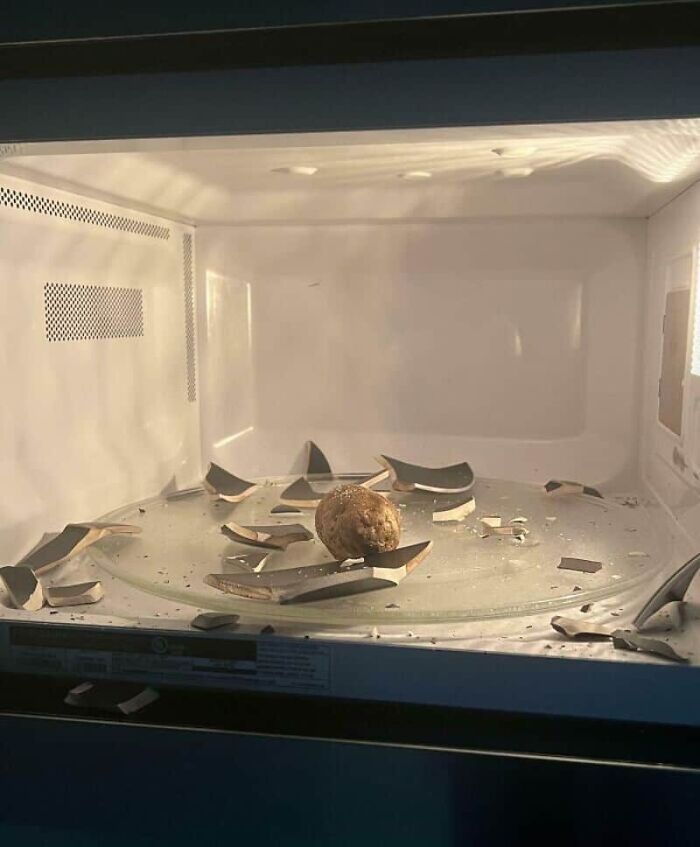 Broken glass shards in a microwave oven, illustrating unfortunate kitchen fails.