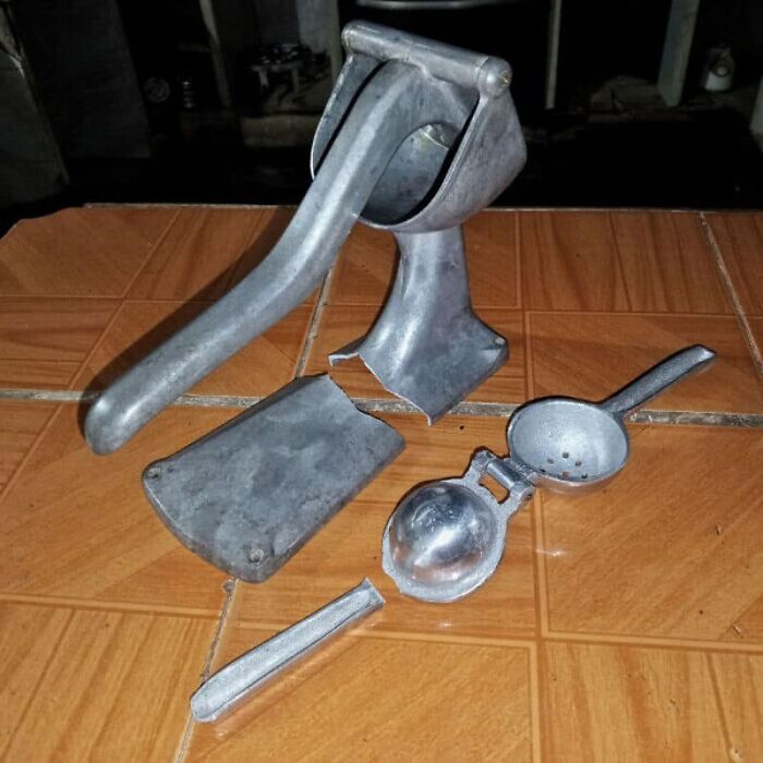 Disassembled juicer on a tiled floor, one of many unfortunate kitchen fails.