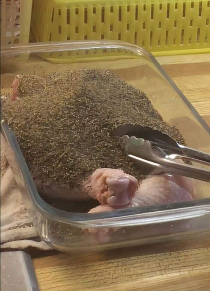 A raw turkey completely covered in a thick layer of seasoning, an unfortunate kitchen fail in prep.