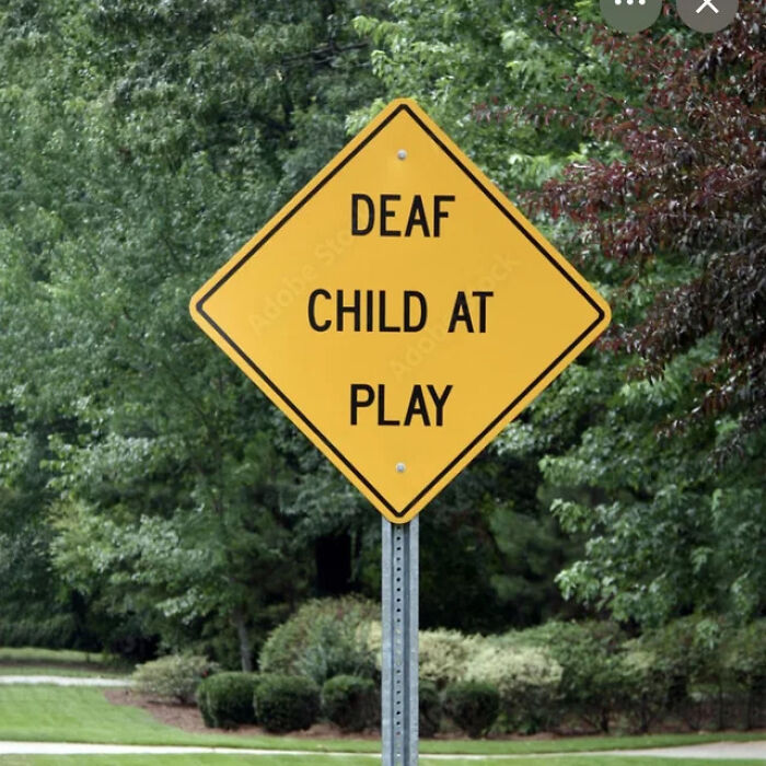 A yellow diamond road sign reading Deaf Child At Play, showing a sign mistake in wording.