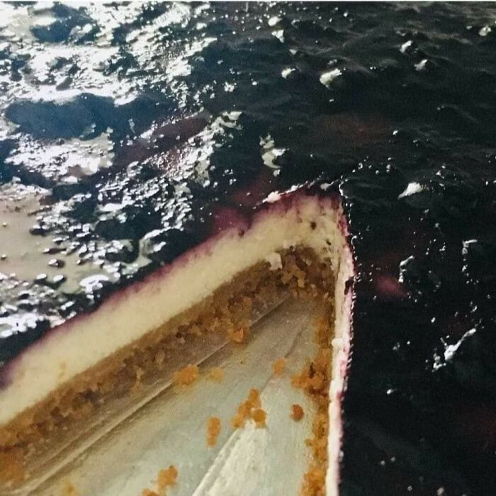 Close-up of a blueberry cheesecake with a missing slice, showing a confusing perspective that looks like the night sky.