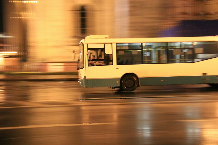 A blurry image of a white and blue bus moving fast at night, relating to ridiculous arguments.