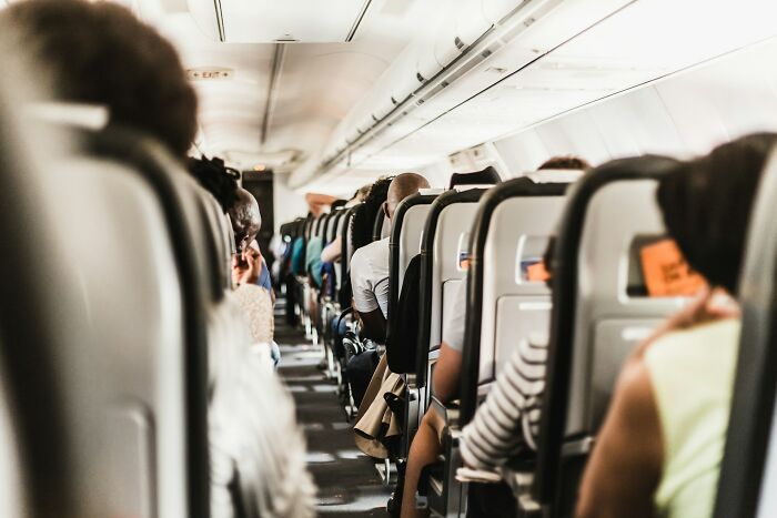Passengers seated in rows on an airplane, illustrating a typical plane seatmate arrangement.