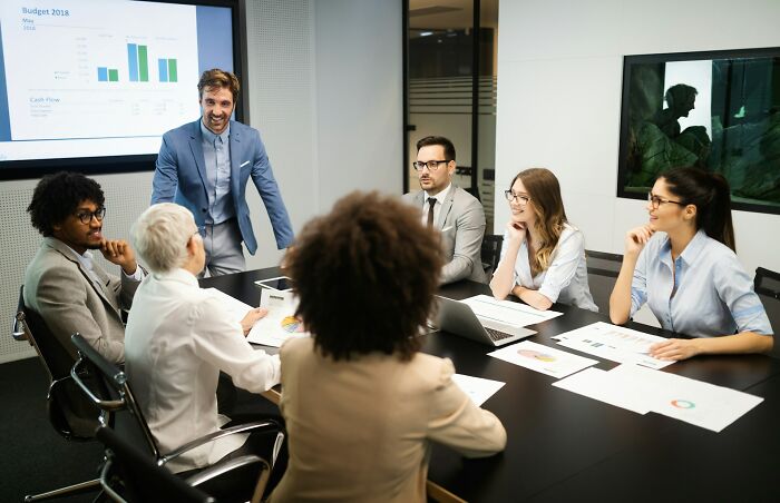 A group of diverse professionals in a meeting, discussing various stereotypes about the US.